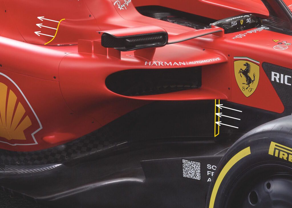 A close-up image of a 2023 Ferrari F1 car showing the side front duct with arrows