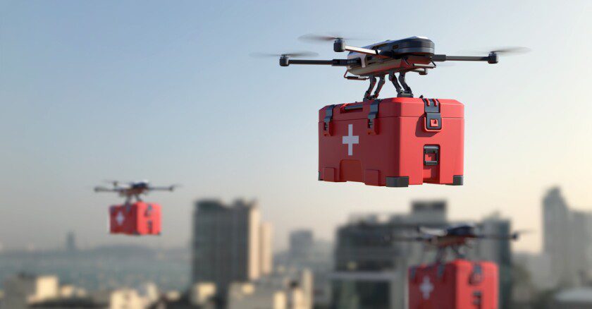 Drones carrying red medical boxes flying through a city