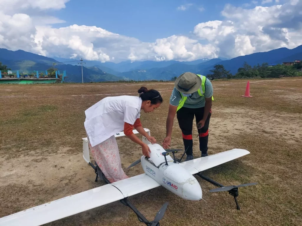 A woman and a man placing medications in a medical delivery drone